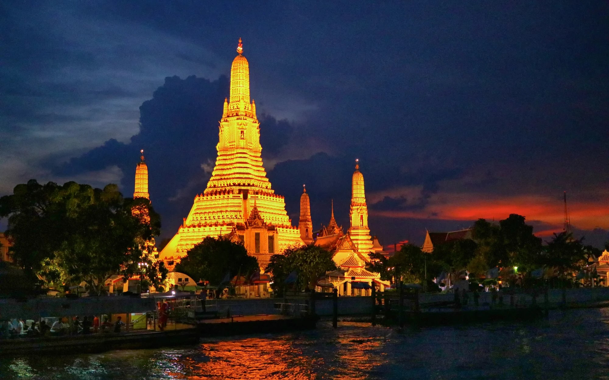 Illuminated Wat Arun beside the Chao Phraya River in Bangkok