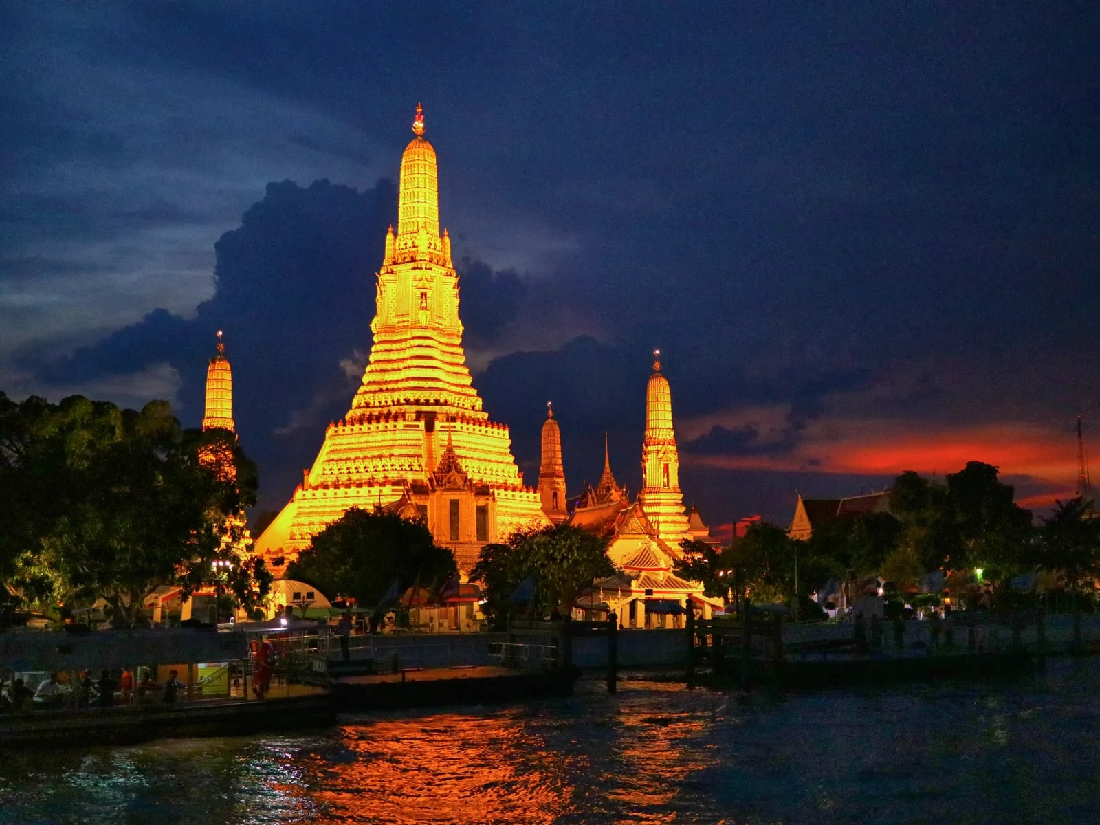 Illuminated Wat Arun beside the Chao Phraya River in Bangkok