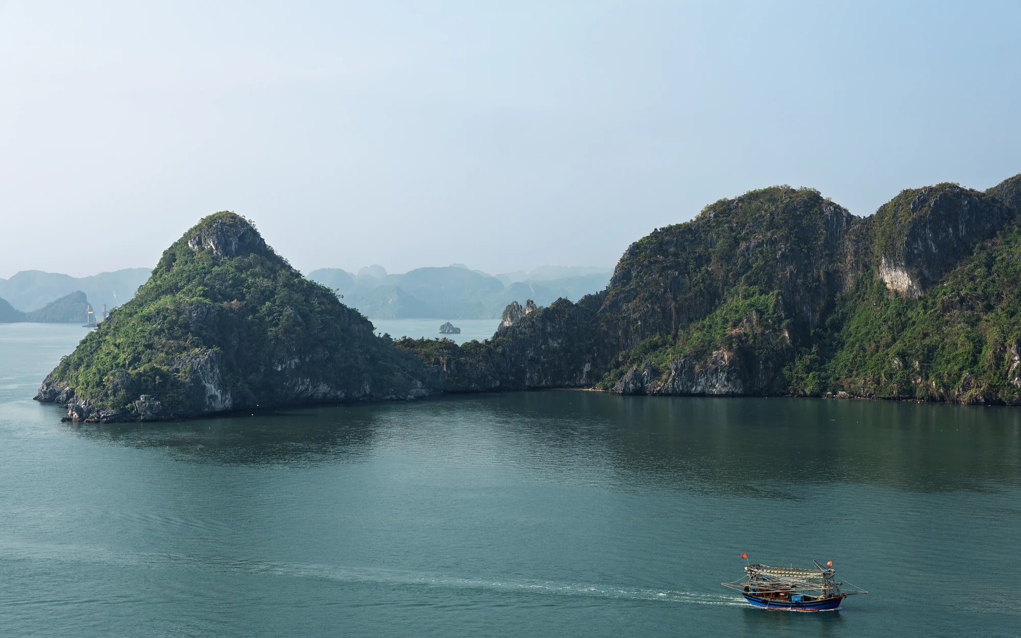 Limestone islands and a small boat in Ha Long Bay