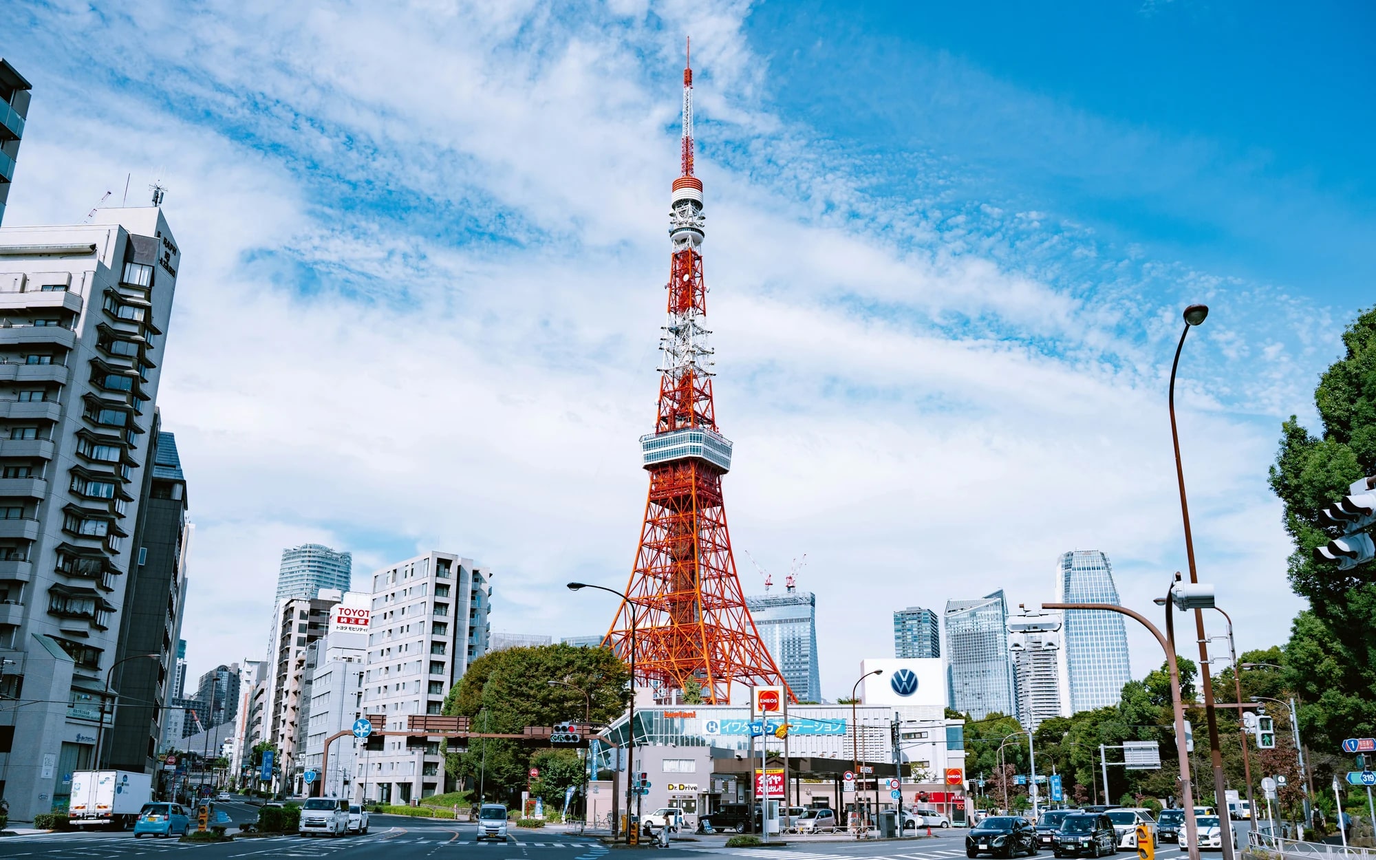 Tokyo Tower above green trees under a blue sky